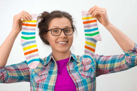 Young female holding two colorful socks in a white backgroundの写真素材