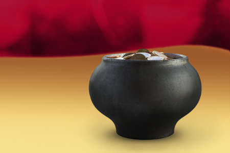 Dark metalic pot with euro currency in a red yellow backgroundの写真素材