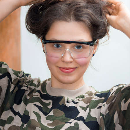 Smiling girl with goggles and military shirtsの写真素材