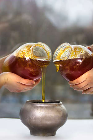 Two jars with honey, pot and four womans handsの写真素材