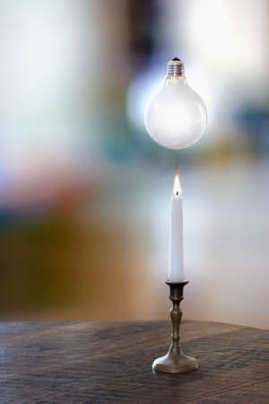 White candle and a bulb in a blurry backgroundの写真素材