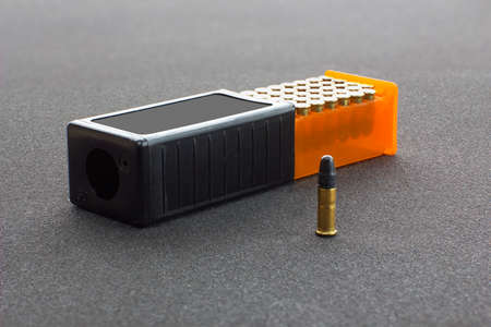 Small caliber cartridges in a plastic box in a rough grey background