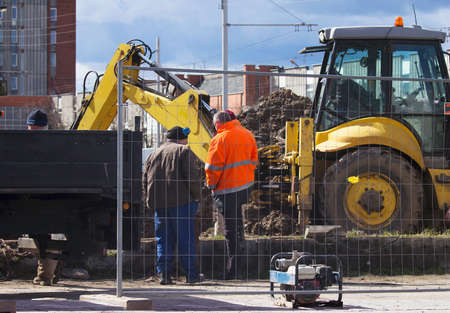Workers and excavator on a  thermal underground  network repairの写真素材