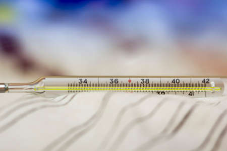 Mercury thermometer in a hot blurry background