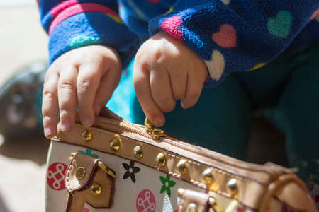 Little girl's hands opens a big walletの写真素材