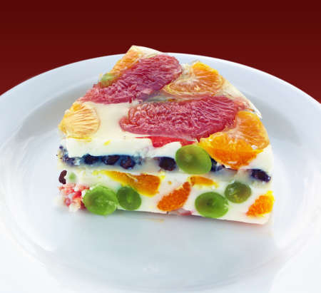 Close view of a piece of a colorful jelly cake with fruits