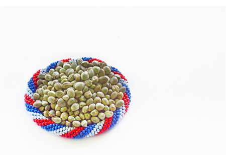 Hemp seeds in a bracelet of flag colours in a white background