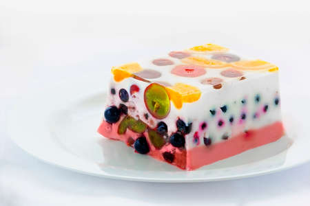 Close view of a piece of a colorful jelly cake with fruitsの写真素材
