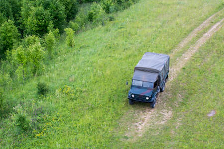 Old military truck near a water body on a grass