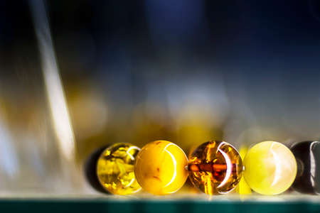 Close view of amber bracelet on a glass in a blurry backgroundの写真素材