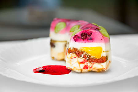 Close view of a piece of a colorful jelly cake with fruitsの写真素材