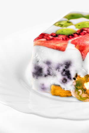 Piece of jelly fruit cake with milk on a white plateの写真素材