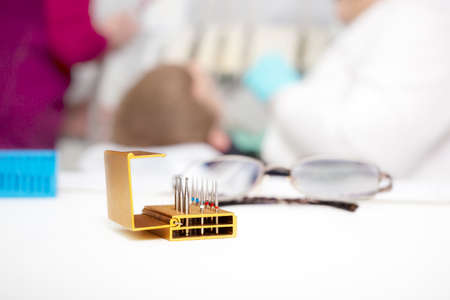 Set of dentist drills and eyeglasses on a dentist tableの写真素材