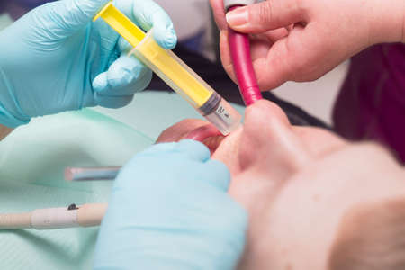 Dentist injected with a syringe to patient's teeth  in a clinic
