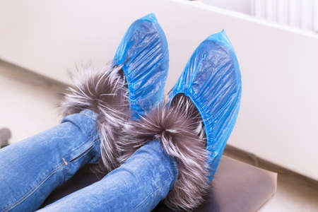 Overshoes on woman's shoes in dental clinic