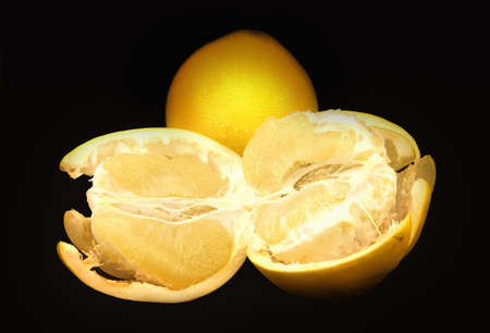 Two pomelo fruits  on a black backgroundの写真素材