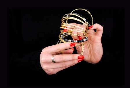 Woman's hands with golden bracelets in a black backgroundの写真素材