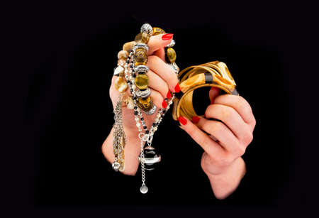 Woman's hands with various bracelets in a black background