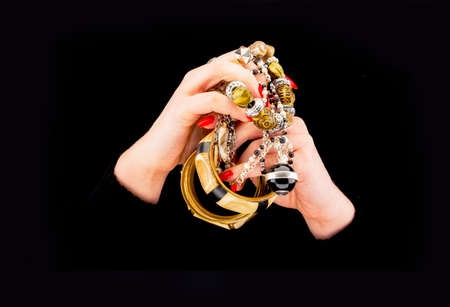 Woman's hands with various bracelets in a black backgroundの写真素材