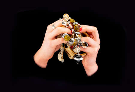 Woman's hands with various bracelets in a black backgroundの写真素材