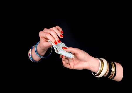 Female's hand giving to  other woman's hand euro banknotes in a black background