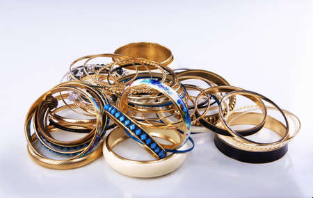 Lots of various golden bracelets on a white backgroundの写真素材