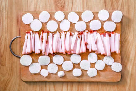 Raw salty pork fat with white radish on a wooden boardの写真素材