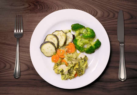 Homemade chicken stew with broccolis and other vegetables served on a wooden tableの写真素材