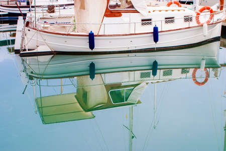 White boats and yachts with their reflections on a water  in the quayの写真素材
