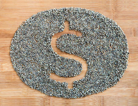 Dollar symbol made of hemp seeds  on a wooden bamboo boardの写真素材