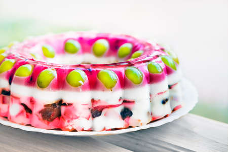 Jelly cake with fruits on a white plateの写真素材