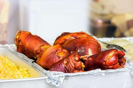 An outdoor vendor sells smoked and grilled pork knuckles or ham hockの写真素材