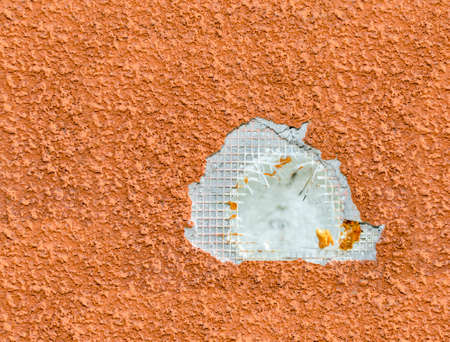 Close view of a destroyed polystyrene insulated wall. Hole on it. Looks polystyrene, reinforcing...