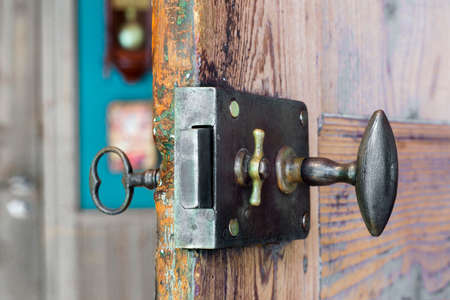 Close view of an old lock and key in a wooden doorの写真素材