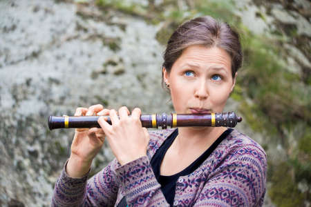 Young woman playing an indian wooden flute