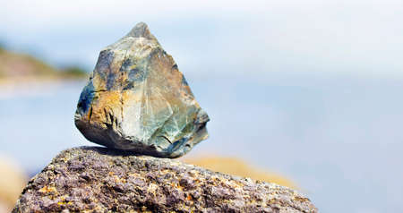 Stone on a rock near seashore in Norway with a blurry backgroundの写真素材