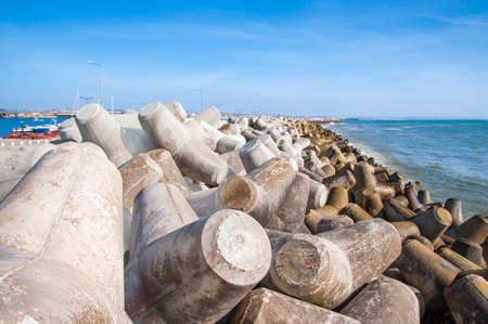 Close view of a breakwater in Portugal seashore formed by big concrete blocksの写真素材