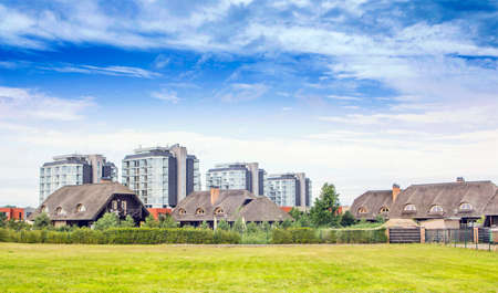 Thatched houses with a dormers. Old and new styles of architecture 