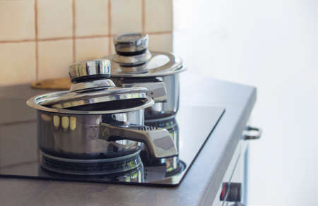 Stainless steel cooking pot on a stove in a kitchenの写真素材