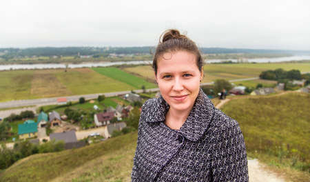 Young woman on a hill top and view from itの写真素材