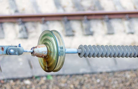 High-voltage ceramic insulator on railway tracks backgroundの写真素材