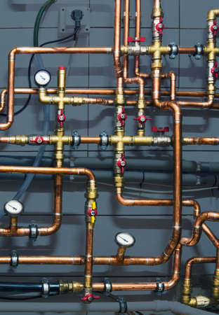 Copper valves and pipes on a grey background