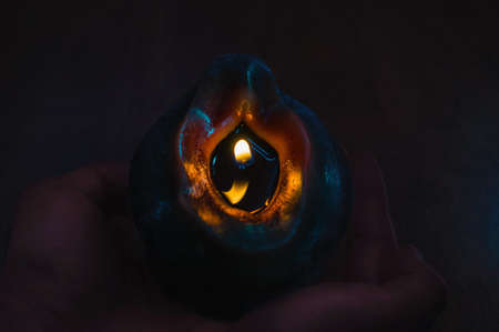 Close up of  a candle  in hands in a dark backgroundの写真素材
