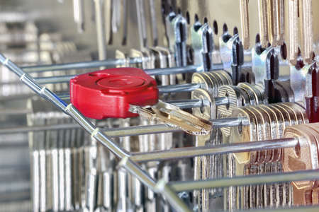 Blank keys on a special wall in a workshop. One of them is redの写真素材