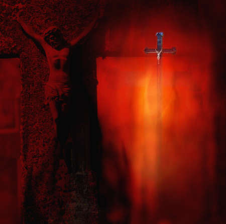 Small and big metal sculpture of the crucified Christ on the cross in a dark red background of the burningの写真素材
