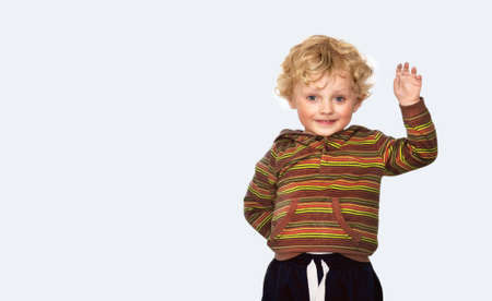 Happy little boy showing something with his hand on a white backgroundの写真素材