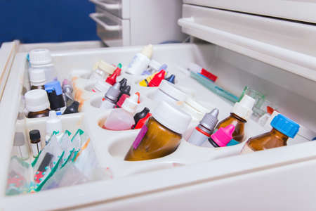 Close up photo of dentistâs tools drawer with various small bottlesの写真素材