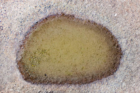 Stone surface with a small puddle on itの写真素材