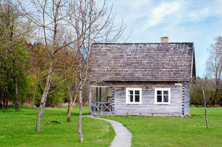 Old wooden house with white windows surrounded by beautiful natureの写真素材