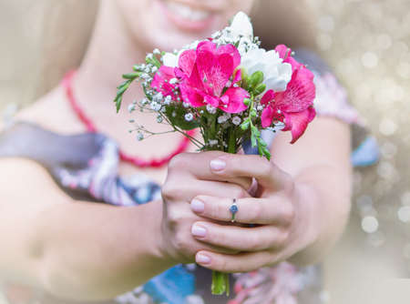 Girls hands with bouquet of flowersの写真素材